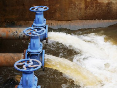 Beş mavi borusu olan endüstriyel drenaj sistemi bir su deposuna su boşaltıyor. Su yönetimi kavramı, atık su arıtımı ve çevre mühendisliği, sızıntı yolu