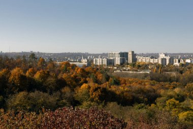 Şehir bir sonbahar ormanının arka planına karşı.