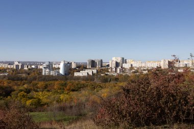 Şehir bir sonbahar ormanının arka planına karşı.