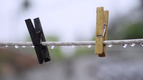 Две Деревянные Веревки Висящие Белом Тросе Покрытом Дождевыми Каплями Дождливый — стоковое видео