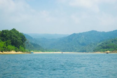 Yukarıdaki berrak gökyüzünü yansıtan dingin mavi sular huzur ve huzur hissi yaratıyor..