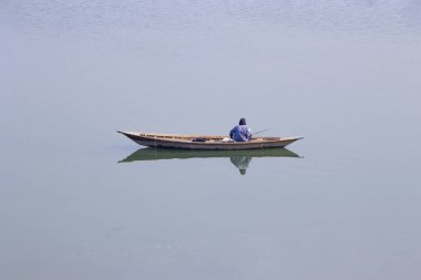 Jamuna nehrinde bir balıkçı ve teknenin özel bir yansıması.