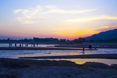 Gündüz geceye geçerken Sylhet 'in dingin güzelliğini yakalayın. Bu nefes kesen günbatımı sahnesinde turuncu, pembe ve mor renkli canlı renkler Sylhet 'in sakin tepeleri ve yemyeşil yeşillikleri üzerine sıcak bir parıltı saçıyor.. 