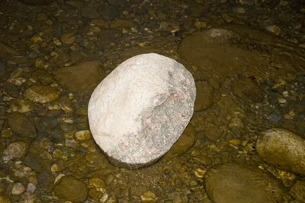 Bu çarpıcı fotoğraf büyük, heybetli bir taşı gösteriyor. Kısmen sakin, kristal berrak suya batmış.. 
