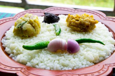 An authentic Baisakhi food spread featuring steaming white rice served with a side of creamy mashed potatoes, garnished with fresh onions and vibrant green chilies clipart