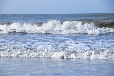 Okyanusun ham gücünü ve güzelliğini kıyıya çarpan dalgalarla yakalayın. Görüntü denizlerin dinamik hareketlerini gösteriyor, köpüklü beyaz dalgalar altın kumlara sıçrıyor..