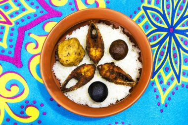 Su pirinci (panta bhat), kızarmış Hilsa balığı (ilish fry), taze yeşil biber ve kırsal bir tabakta servis edilen dilimlenmiş soğan içeren geleneksel bir Bengali yemeği.. 