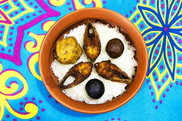 Su pirinci (panta bhat), kızarmış Hilsa balığı (ilish fry), taze yeşil biber ve kırsal bir tabakta servis edilen dilimlenmiş soğan içeren geleneksel bir Bengali yemeği.. 