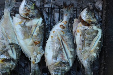 Açık havada balık pişiriyorum. Izgarada balık pişirme ve kızartma. Kömürde kızartılmış balık. Yaz zamanı ve sağlıklı yemek fikri. Üst görünüm.