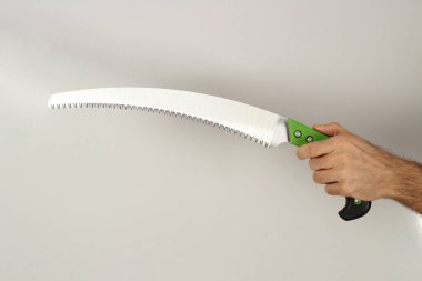 Elinde budama testeresi olan adam beyaz arka planda izole edilmiş. Kapat..