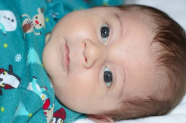 Bebek sırt üstü uzanmış kameraya bakıyor..