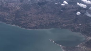 Bulutların üzerinde uçarken hareket halindeki 4k uçağından yere ve denize bakın.