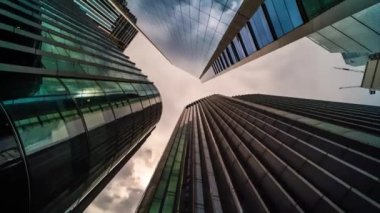 Low angle view on skyscrapers office buildings reflecting clouds, timelapse hype lapse 360 rotating panoramic, London, England