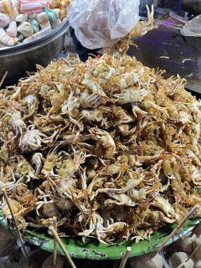 Büyük bir yığın kızarmış küçük yengeç veya mini yengeç koyu yeşil bir tepside servis edilir. Bu popüler sokak yemeğinin altın bir dokusu var..