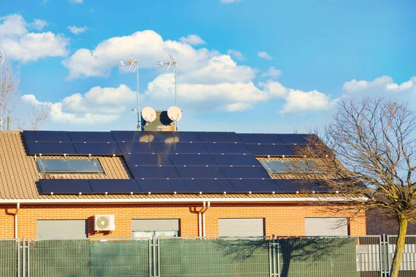 Çatılarda güneş panelleri ve bulutlu gökyüzü olan evler..