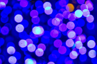 Renkli Noel ışıkları mavi, mor ve turuncu bokeh arka plan.