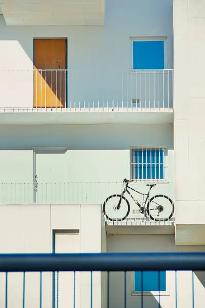 Madrid, Carabanchel 'deki PAU mahallesinde, balkonlu ve bisikletli bir apartmanın ön cephesinde..