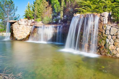Madrid 'in Arroyomolinos kentindeki bir parkta şelaleli bir gölet sergisi (İspanya).