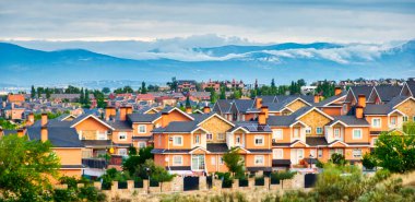 Arroyomolinos, Madrid 'in (İspanya) arka planında sislerle kaplı Sierra de Guadarrama şehri manzarası.