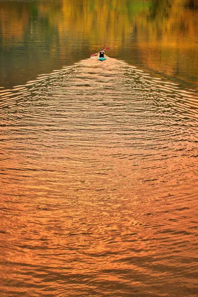 Bir kanocu şafak vakti bir gölün sularında kürek çeker ve uyanır..