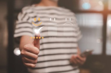 Tatmin olmuş kadın müşteri, sanal ekranda gülümseme yüz ifadesine basıyor. Müşteri değerlendirme konsepti. en iyi derecelendirme pozitif, kalite değerlendirmesi, geri besleme anketi, pazarlama performansı,