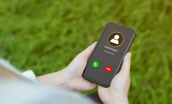 Dolandırıcılık ya da telefon konseptiyle dalavere yapmak. Bilinmeyen numaradan aranan bir kadın cep telefonu tutuyor. Dolandırıcı ya da yabancı, sahte kimlikli bir sahtekar, telefon şakacısı.,