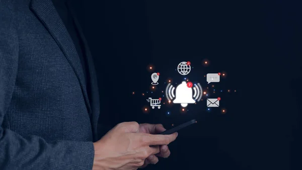 İş adamı, uygulama uyarı konsepti için sanal çan çalan akıllı telefon kullanıyor. Sosyal medya ve internet ağı, e-posta, telefon, sohbet, online alışveriş, harita konumu,