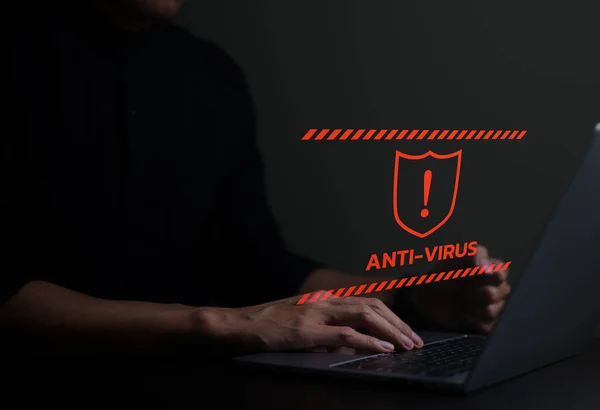 Anti virüs alarmı ve güvenlik duvarı hacker koruması kavramı. İşadamı ya da personel, programcı ya da geliştirici ünlem işareti ve kalkan kırmızı işareti olan bir bilgisayar dizüstü bilgisayar kullanıyor..