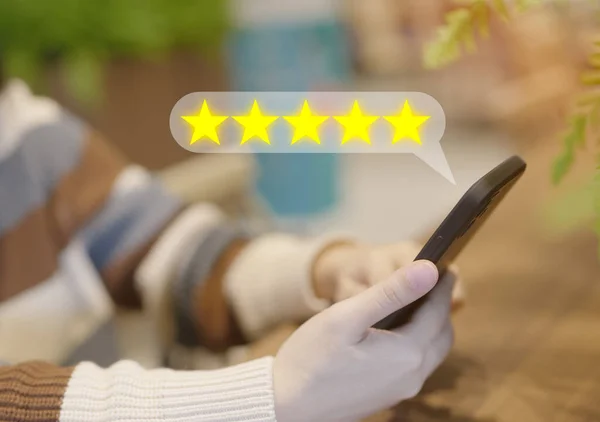 顧客はスマートフォンを使用してオンラインアプリケーションのサービス体験を評価し 品質評価5つ星を評価します 顧客レビュー満足度アンケートフィードバック調査のコンセプト — ストック写真