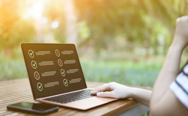 Online dizüstü bilgisayarda kontrol kutularıyla değerlendiren bir kadın. Online değerlendirme anketi, testte doğru cevabı seçin, soru testi, çevrimiçi sınav, sınav bilgisi, anket formu doldurun, kontrol listesi,