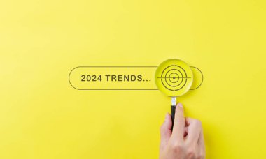 Eğilimler 2024 yıllık konsept. 2024 trend arama çubuğuyla el ele tutuşan büyüteç 2024 iş pazarlama trendleri ve yeni yılda iş planı optimizasyonu. Bilgi ve yeni fikirler bul.