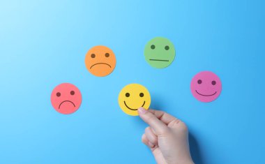 Elle seçilmiş gülen surat ikonu. Müşteri anketi, Müşteri hizmetleri, İş değerlendirmesi, Kullanıcı hizmet deneyimine not verir, Müşteri memnuniyeti değerlendirmesi anket kavramı.