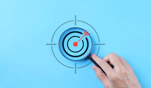 Business goals and target success concepts. Holding a magnifying glass with bullseye icon. Aim business, Business Growth, Goal objective strategy plan action, Target success, achievement company,