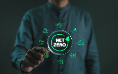 Ağ Sıfır emisyon konsepti. Karbon azaltma ikonlarına büyüteç tutan adam. Karbon ayak izi, karbon nötr, CO2 nötr, sürdürülebilir enerji, iklim değişikliği, sera gazı, küresel ısınma,