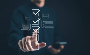 İşadamı dijital kontrol listesi arayüzü ile etkileşimde. Kalite kontrol ve iş onayı proje konsepti için onay kutusundaki işaret doğru. Kontrol işareti, form kontrol listesi dolduruluyor, Çevrimiçi sınav,