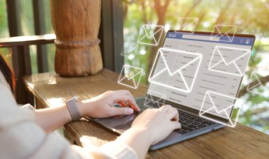 E-posta konsepti. Güneşli bir açık havada dizüstü bilgisayarda e-posta iletişimini yöneten bir kadın, modern uzaktan çalışmayı resmediyor. E- posta, bildirim, gereksiz posta, spam virüsü ve şifrelemeyi kontrol et, E- posta gönder, Gelen Kutusu,