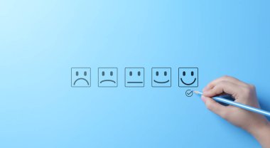 Müşteri memnuniyeti derecelendirme puanı gülen yüzlü. Bir el, müşteri memnuniyeti anketinde üzgün ile mutlu arasında değişen çeşitli duygu seçenekleri içeren mutlu bir yüzü işaretler..