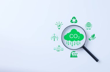 Çevresel Simgelerle Karbon Ayak İzi Araştırması. Beyaz arka planda çeşitli yeşil enerji ve çevre sembolleriyle çevrili CO2 emisyon ikonuna odaklanan büyüteç.