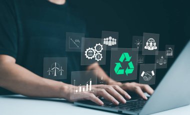 Sürdürülebilir kalkınma planlama kavramı. Geri dönüşüm, yenilenebilir enerji ve çevre korumasıyla ilgili sanal simgelere sahip bir dizüstü bilgisayar kullanan kişi. ESG iş sürdürülebilirlik yatırım stratejisi