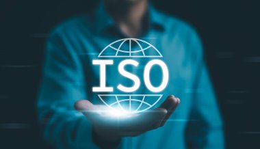 ISO Standartları Kalite Kontrol Güvencesi. Uluslararası kalite kontrol, güvence ve iş teknolojisi standartlarını temsil eden parlak ISO sembolüne sahip iş adamı. ISO standart sertifikası, QC,