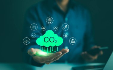 Karbon ayak izi konsepti. İnsan eliyle karbon azaltma ikonu tutuyor. Sıfır ve karbon nötr, karbon emisyonları, CO2 nötr, sürdürülebilir enerji, iklim değişikliği, küresel ısınma, sera gazı,