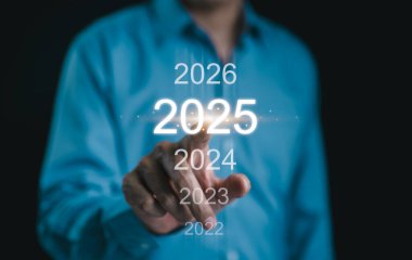 Yeni yılınız kutlu olsun, İşadamı 2025 yılına dijital bir zaman çizelgesinde işaret ederek gelecekteki iş hedefleri, planlama ve stratejik büyüme girişimlerini sembolize ediyor. Şirket stratejisi, İş hedefi,