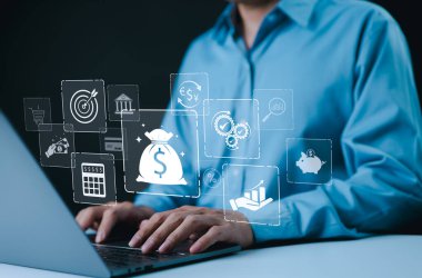 Para konsepti. Dijital simgeli dizüstü bilgisayar kullanan işadamı mali yönetim, tasarruf, yatırım, bankacılık ve parasal işlemleri temsil ediyor. Dijital çağda para ve finans üzerinde duruluyor