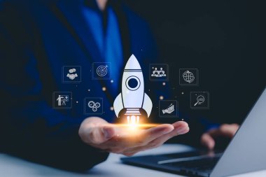 Ticari büyüme ve yatırım simgelerini elinde tutan işadamı, roket fırlatma hızı, hızlı zenginlik, artan kazancı, artan karı gösteren grafikler, finansal başarıyı gösteriyor