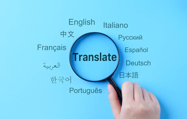Translation and Multilingual Communication Concept. A magnifying glass highlights the word "Translate," surrounded by names of multiple languages, multilingual translation, and global communication.