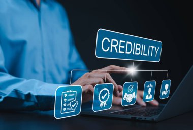 Credibility and trust in business concept. Businessman using laptop with icons credibility, trust, reputation, verification, integrity, reliable, authentic, commitment, regard, and quality assurance.