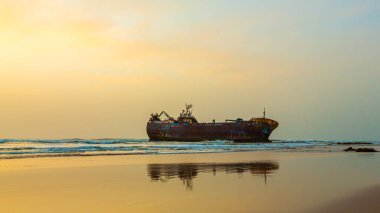 Kumsalda sıkışmış eski bir tekne.