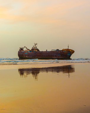 Kumsalda sıkışmış eski bir tekne.