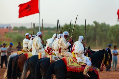 Essaouira, Fas - 13 Ağustos 2023: Biniciler geleneksel Fas kıyafeti ve şövalyelerin aksesuarları içinde Arapça Tbourida adlı geleneksel bir giysi etkinliğine katılıyorlar