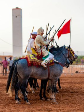 Essaouira, Fas - 13 Ağustos 2023: Biniciler geleneksel Fas kıyafeti ve şövalyelerin aksesuarları içinde Arapça Tbourida adlı geleneksel bir giysi etkinliğine katılıyorlar